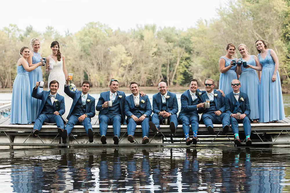 A group of people sitting on top of a wooden dock.