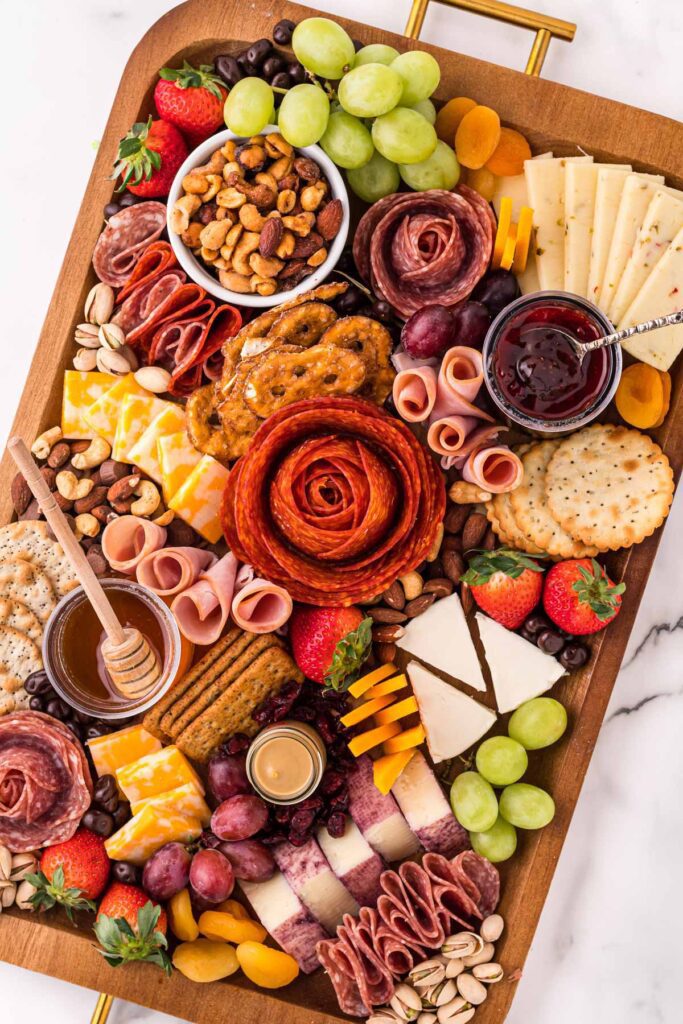 A wooden tray filled with different types of food.