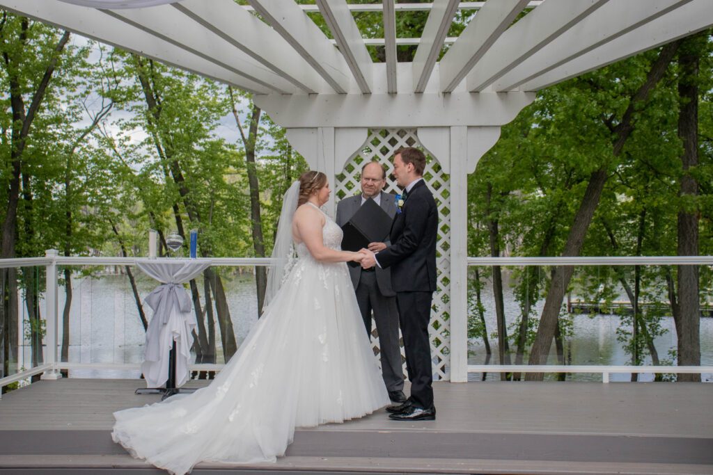 A bride and groom are holding hands at their wedding.