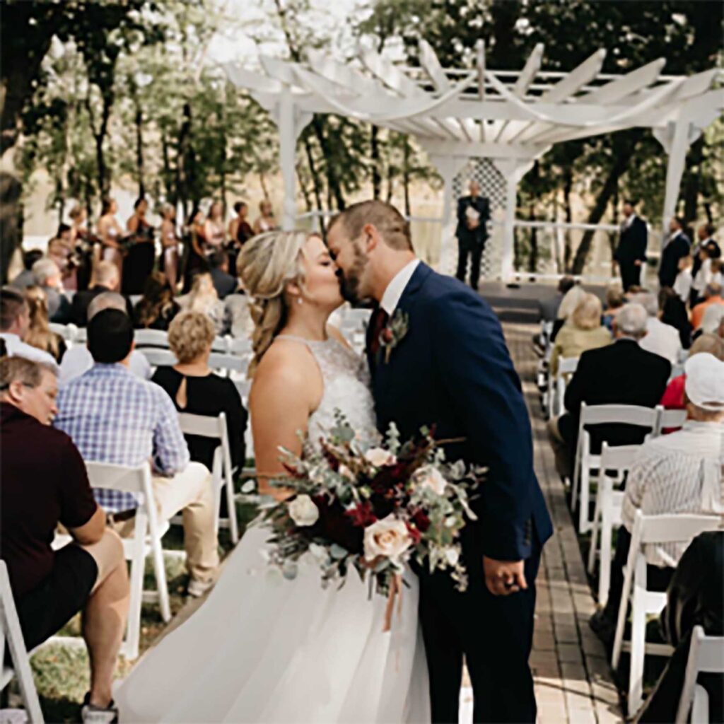Wedding couple is kissing with each other and holding flower