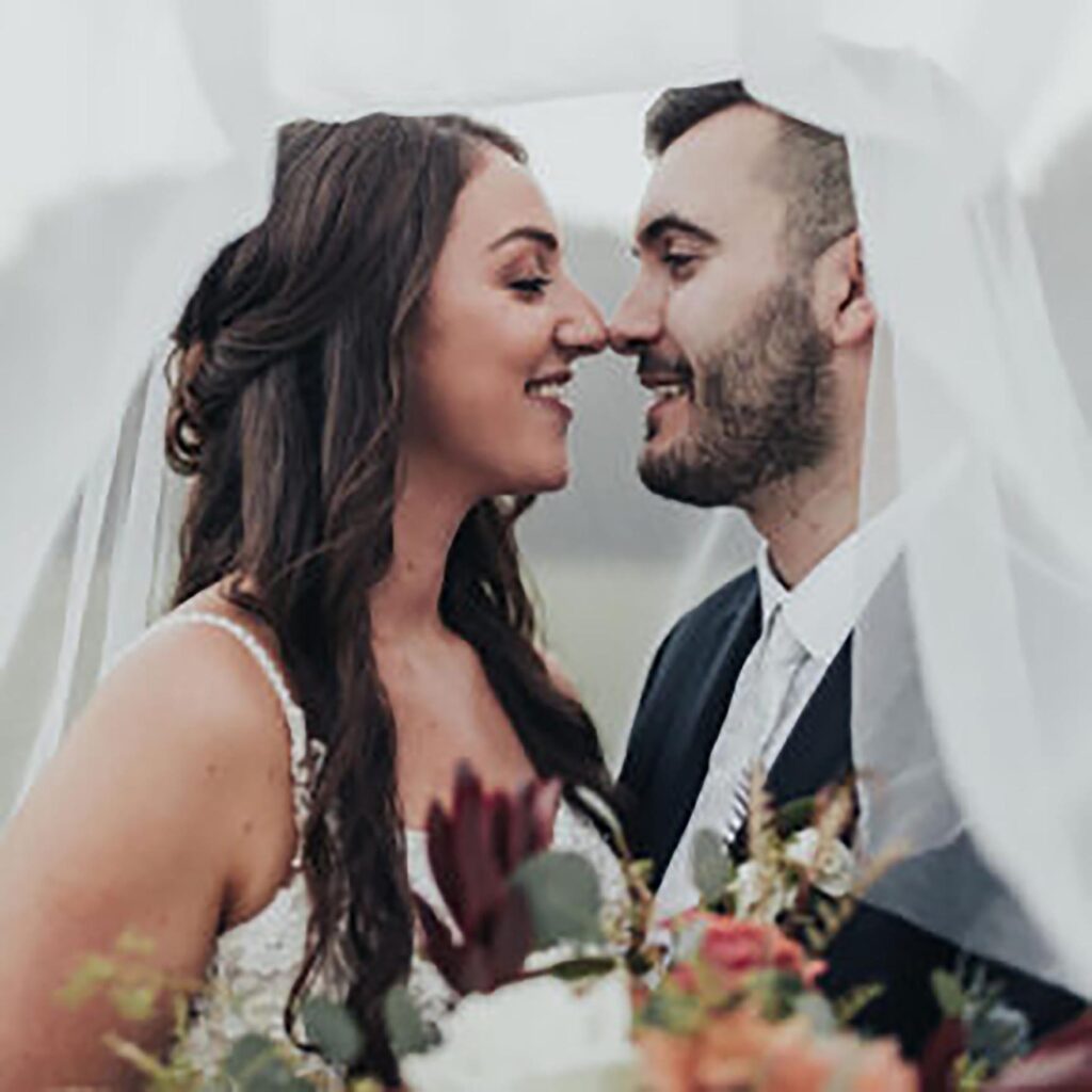 Wedding couple is smiling under the veil