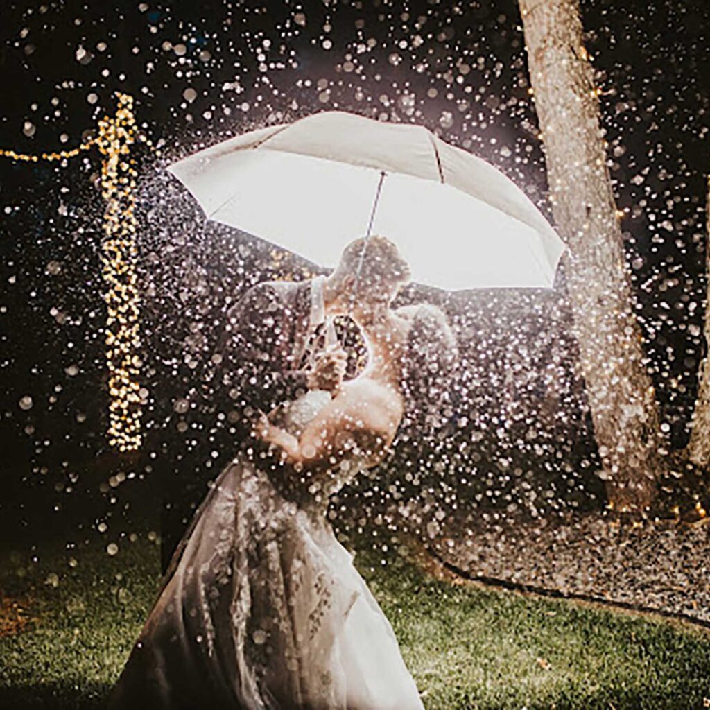 Wedding couple is kissing under the umbrella