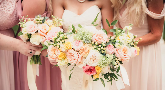 A bride and her bridesmaids holding their bouquets.