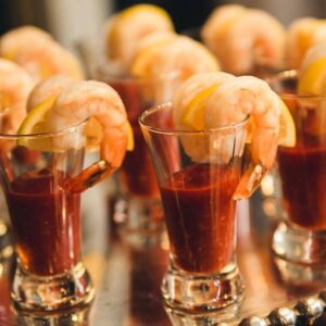A table with several glasses of shrimp cocktails.