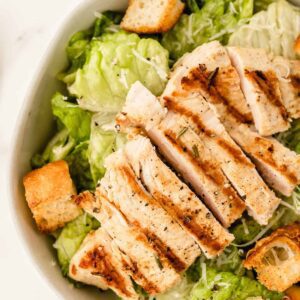 A salad with chicken and croutons in it.
