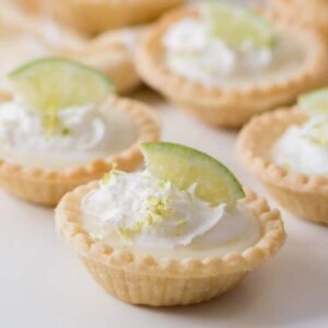 A close up of some mini pies with lime slices