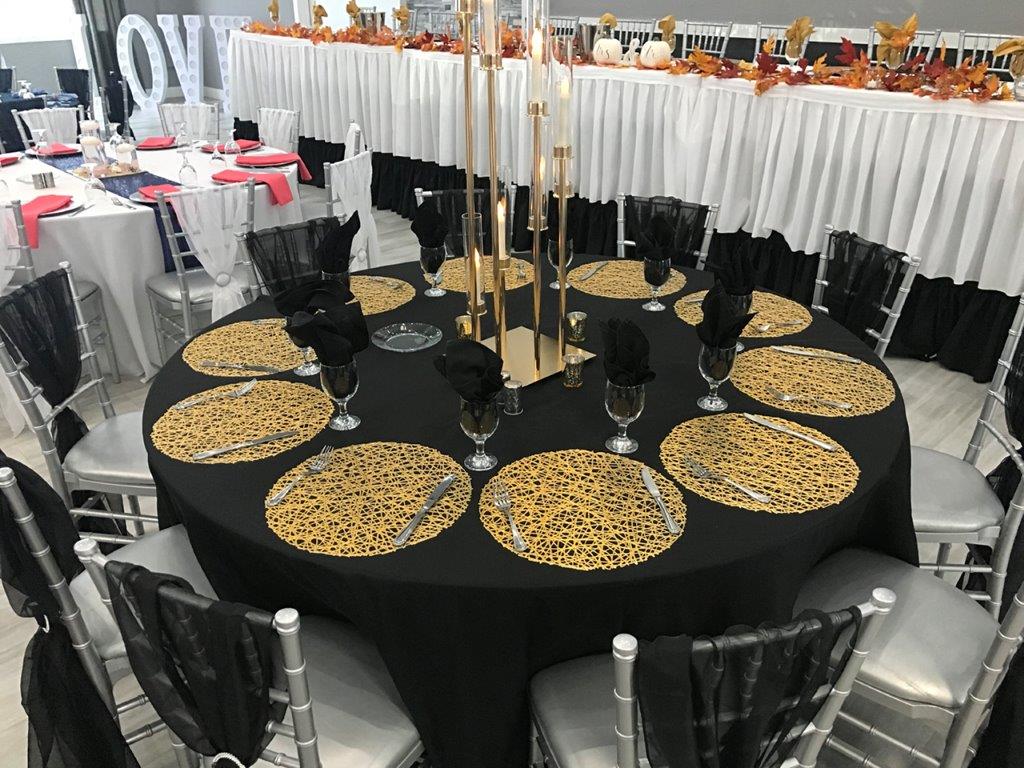 A table set up with black and gold plates