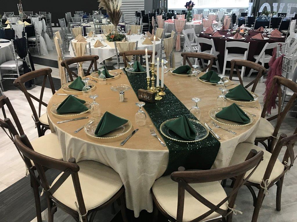 A round table with green napkins and candles.