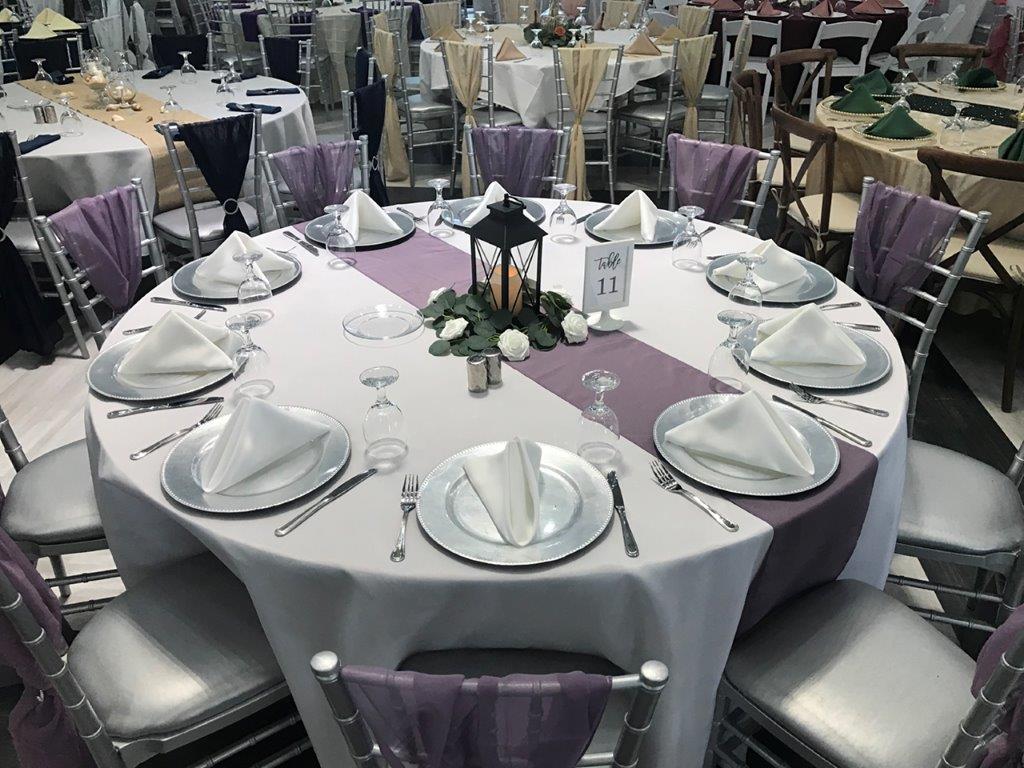 A table set up with silverware and plates.
