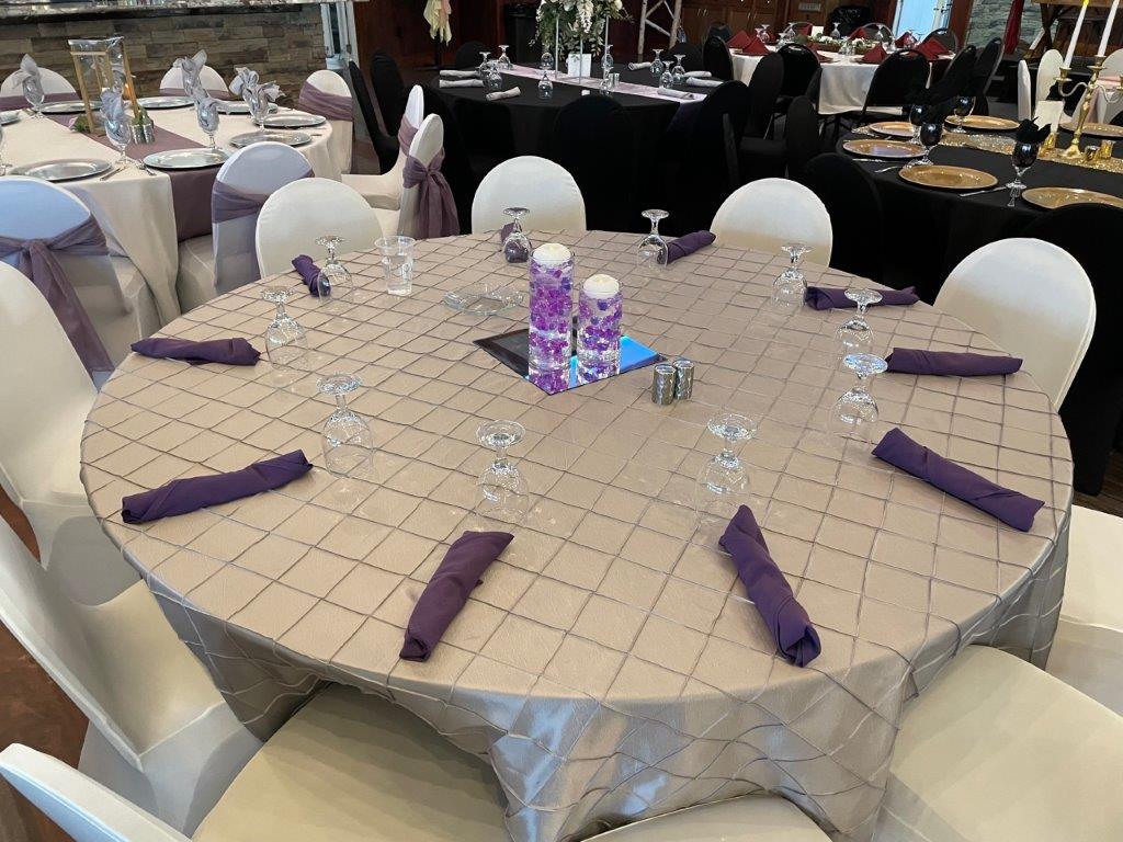 A table with purple napkins and glasses on it