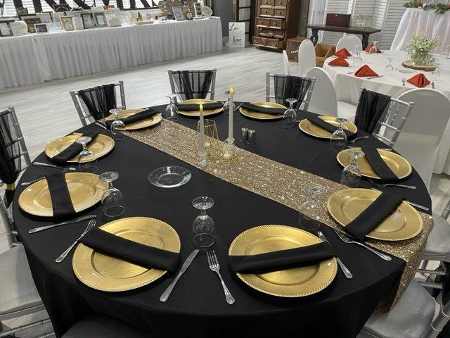 A table set with gold plates and silverware.