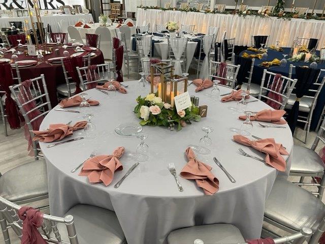 A round table with many place settings and candles.