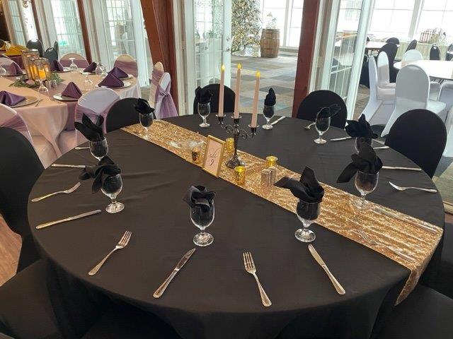 A table with black cloth and silverware on it