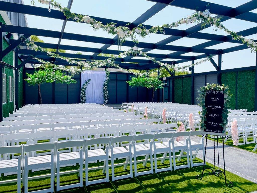 A large outdoor wedding venue with white chairs.