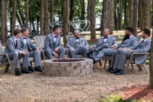 A group of men sitting around a fire pit.