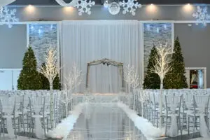 A white wedding ceremony with trees and snow.