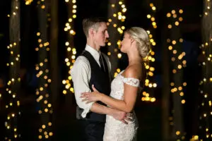 A man and woman are dancing in front of lights.