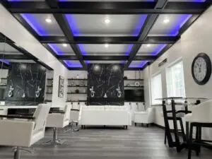 A room with a black and white wall, chairs, tables and lights.