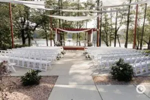 A wedding ceremony with white chairs and trees