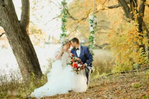 A bride and groom kissing in the woods