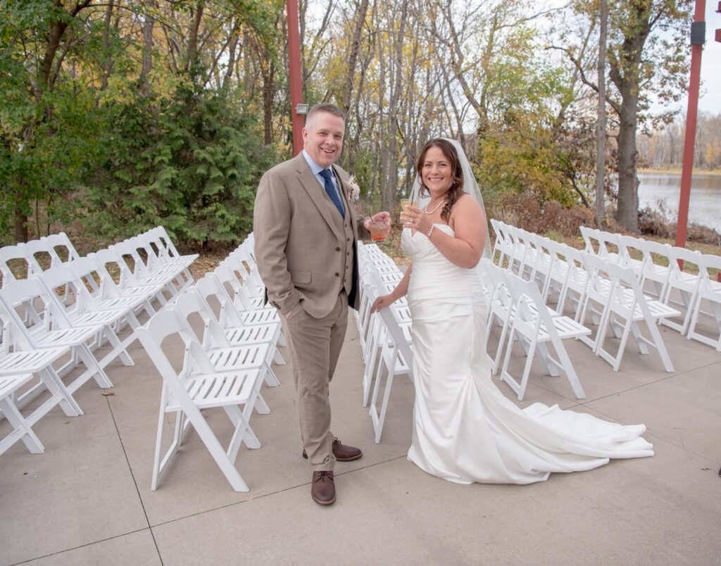 Newlyweds just married by the riverside altar - enjoying a first drink after the ceremony