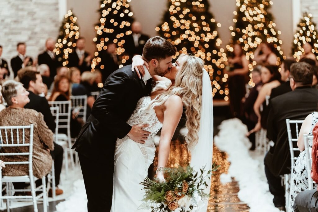 Newlyweds kissing after married at a indoor winter wedding ceremony